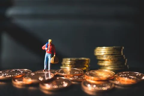 Miniature people, man standing on stack coins Stock Photos