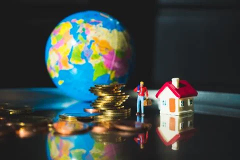 Miniature people, man standing with stack coins Stock Photos