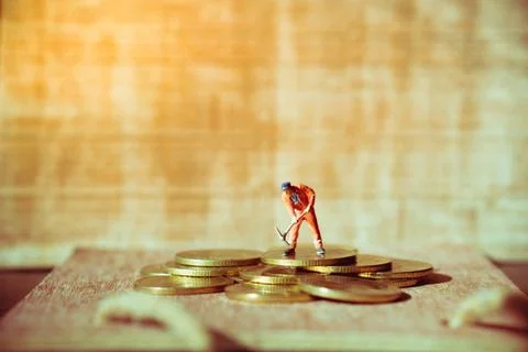 Miniature people, mechanic working on stack coins Foto stock