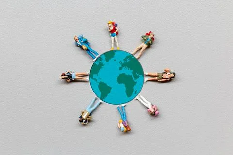 Miniature people standing on the globe with gray background Stock Photos