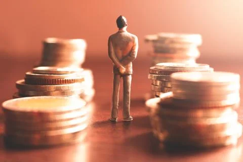 Miniature people standing with stack coin about financial and money savings c Stock Photos
