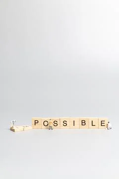 Miniature people worker team on impossible word in wooden alphabet letters Stock Photos