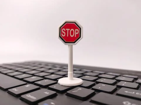 A miniature red and white octagonal stop sign model stands upright fixed on.. Stock Photos