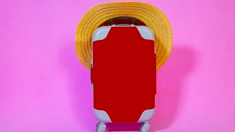 Miniature red suitcase movement with straw hat Stock Footage 287702368