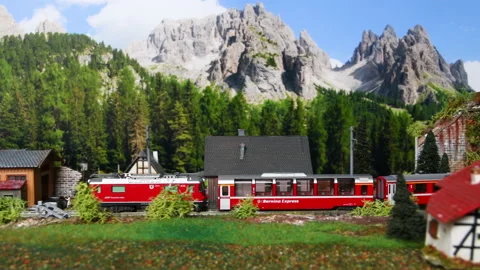 Miniature red train moving through a mountain environment. Stock Footage 236287695