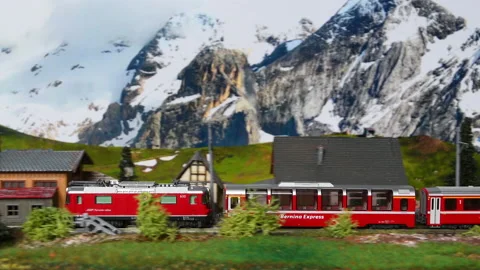 Miniature red train moving through a mountain environment. Stock Footage 236287704