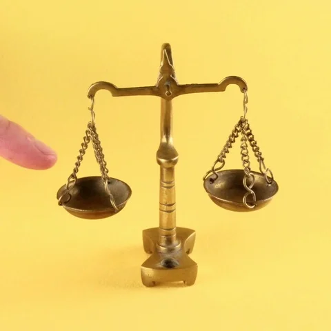 Miniature scale of justice making it's decision. Stockbeeldmateriaal 91296855