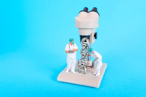 Miniature Scientists Analyzing DNA Structure Under Microscope On Blue Backg.. 스톡 사진