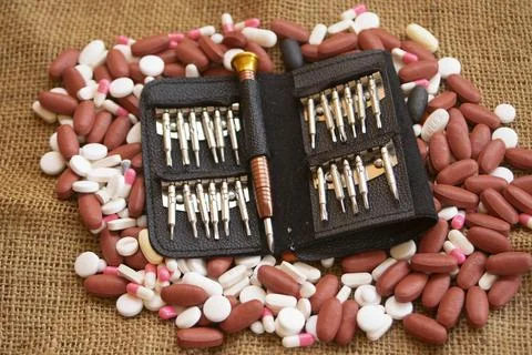 Miniature tool kit surrounded by pills 库存照片