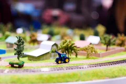 Miniature tractor loads a haystack. Stock Photos