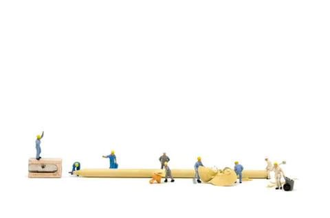 Miniature worker team sharpening a pencil Stock Photos