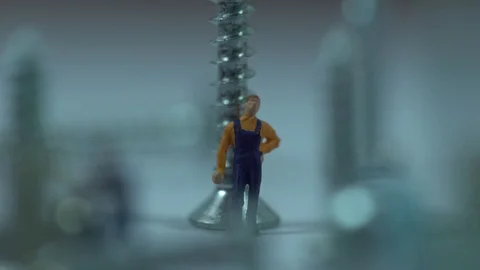 Miniature workers work between metal screws 스톡 동영상 127112558