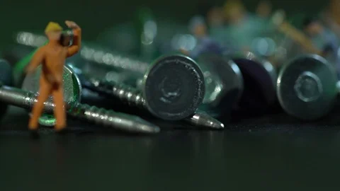 Miniature workers work between metal nails Stock Footage 127169569