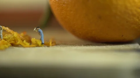 Miniature workers work on orange peel 스톡 동영상 127169497