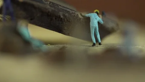 Miniature workers work on a piece of chocolate Stock Footage 127169029