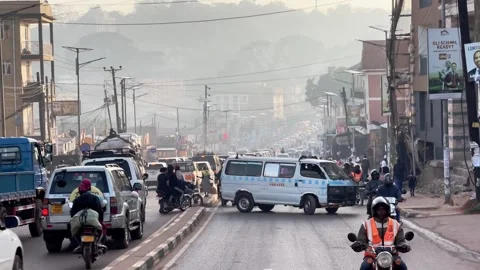Minibus crossing congested urban road with heavy traffic in Kampala city Stock Footage 333620913