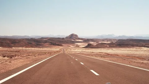 Minibus passing by the empty asphalt road into the distance in the wild desert Stock Footage 254271007
