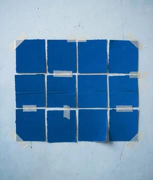 Minimal abstract composition featuring a grid of blue paper squares. Stock Photos
