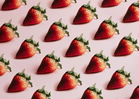 Minimal and repetitive pattern of delicious strawberries over a pastel pink.. Stock-Fotos