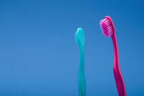 Minimal argument relationship concept using pink and blue toothbrushes Stock Photos
