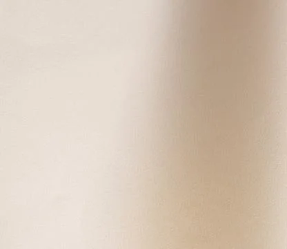Minimal beige textured wall with soft light. Neutral indoor surface for Stock Photos