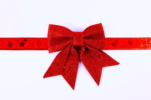 Minimal Christmas background featuring a red glitter bow with decorative ribbon Stock Photos