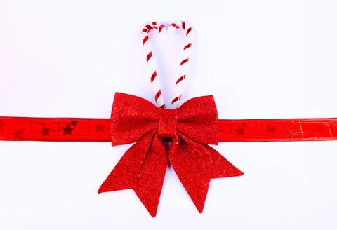 Minimal Christmas background featuring a red glitter bow with decorative ribbon Stock Photos
