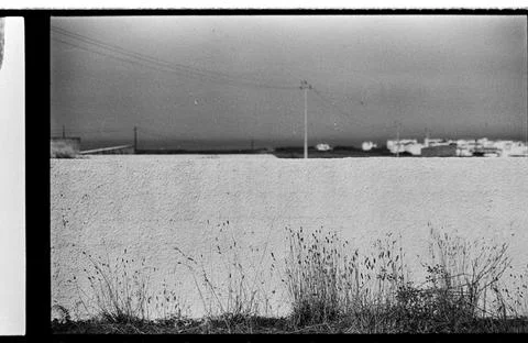 Minimal Coastal Wall and Distant Harbor in Black and White Stock Photos