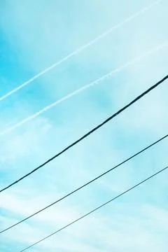 Minimal composition of a bright blue sky crossed by diagonal power lines an.. Stock Photos
