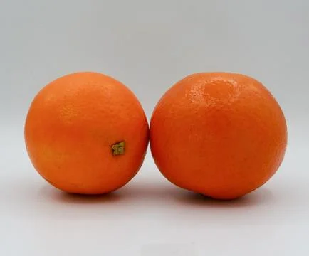 Minimal composition featuring two whole oranges side-by-side on a clean white Stock Photos