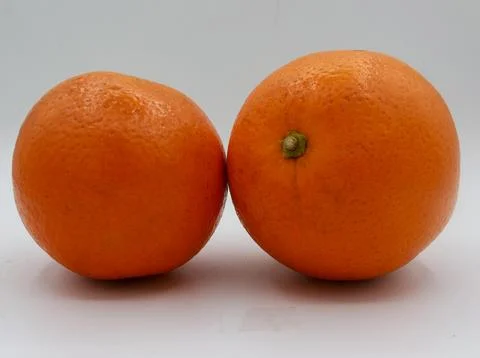 Minimal composition featuring two whole oranges side-by-side on a clean white Stock Photos