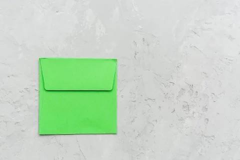 Minimal composition with green envelope on a gray concrete background. Mockup Stock Photos