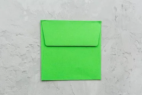 Minimal composition with green envelope on a gray concrete background. Mockup Foto stock