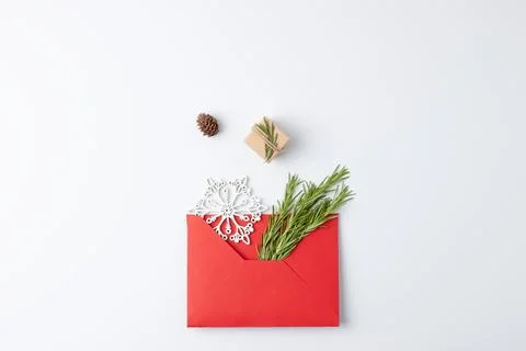Minimal composition with red envelope, gift and Christmas natural decoratio.. Stock Photos