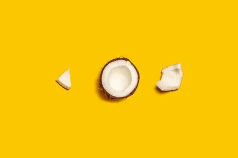 Minimal concept. Pattern with ripe coconuts on yellow background. Stock Photos
