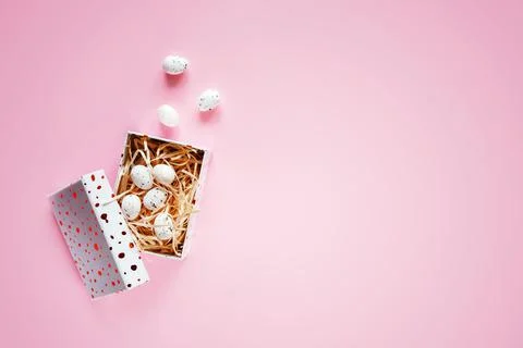 Minimal Easter background with Easter eggs in a gift box on pink background 스톡 사진