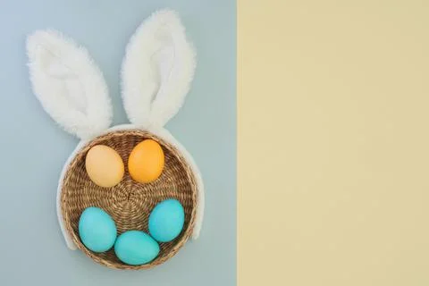 Minimal easter composition with bunny ears and colorful easter eggs on yellow Stock Photos
