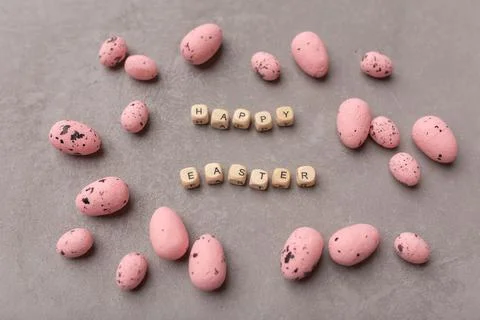 Minimal Easter concept. Pink easter eggs with text Happy Easter on grey Stock Photos