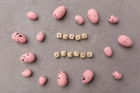 Minimal Easter concept. Pink easter eggs with text Happy Easter on grey Stock Photos