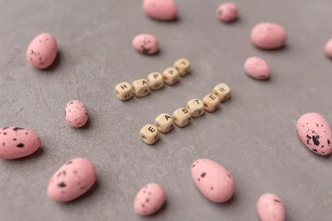 Minimal Easter concept. Pink easter eggs with text Happy Easter on grey Stock Photos