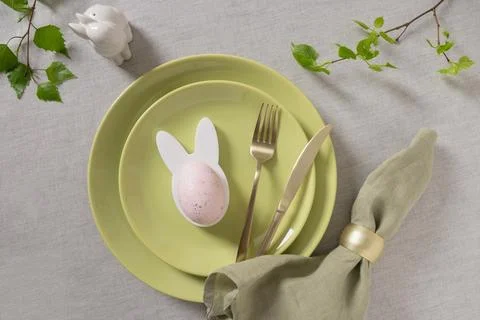 Minimal Easter place setting with green plates and linen napkin Stock Photos