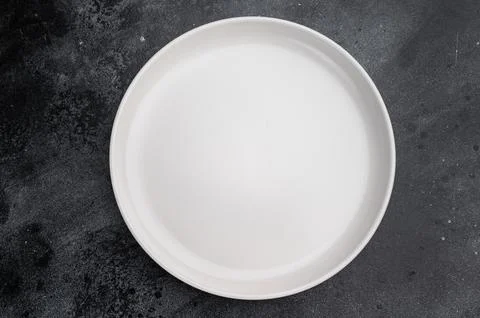 Minimal empty plate on dark background with texture. Modern ceramic tablewa.. Stock Photos