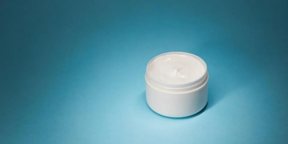 Minimal Face Cream Pot On Blue Studio Background, Horizontal Banner 库存照片
