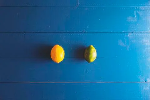 Minimal flat lay view of lime, lemon over blue vintage backdrop with copy spa Stockfoto's