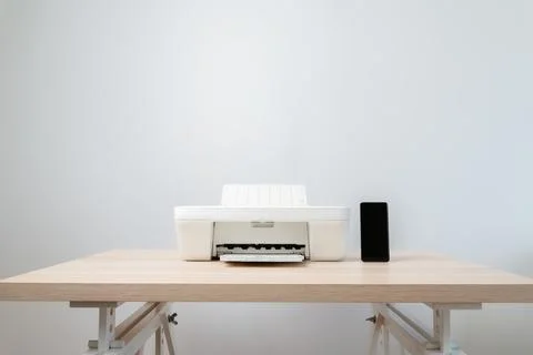 Minimal Home Office Printer With Smartphone On Wooden Desk Against Neutral .. Stock Photos