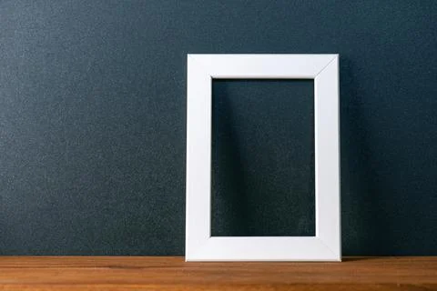 Minimal interior composition with black wall and white blank photo frame Stock Photos
