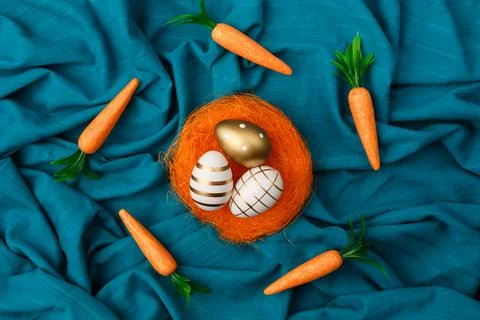 Minimal layout of golden Easter eggs  in orange nest with bunny carrot circli Stock Photos