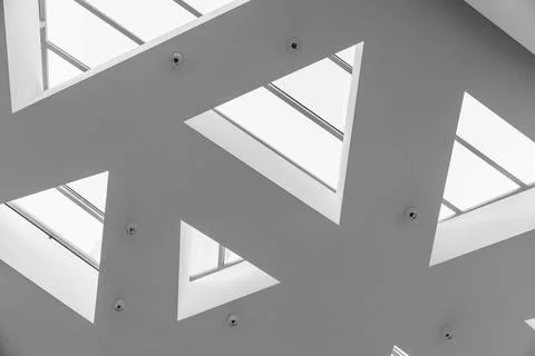 Minimal modern ceiling design with triangular skylights creating a geometri.. Stock Photos