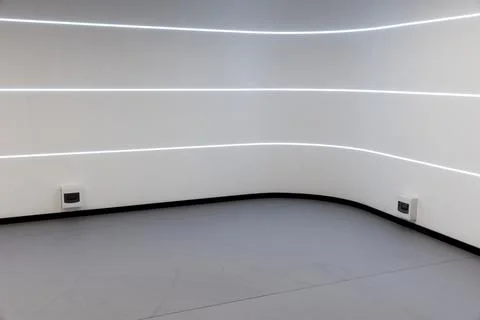 Minimal modern interior featuring a curved white wall with LED lines Stock Photos