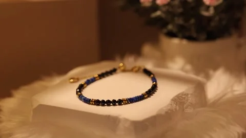 Minimal natural stone bracelet on rotating display stand in close view 動画素材 337420346